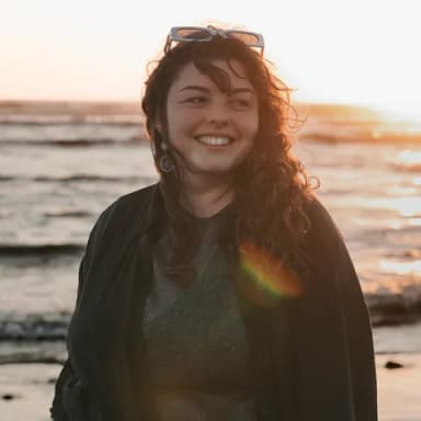 Kateřina Nastoupilová, usměvavá žena s kudrnatými vlasy u moře
